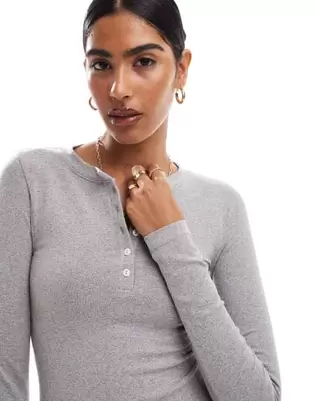 ASOS DESIGN – Nahtloses, langärmliges, modellierendes Henley-Oberteil in Grau meliert für 19€ in ASOS